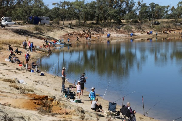 People fishing on the banks of the Wimmera River.